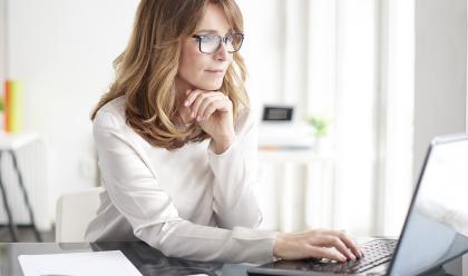 woman on computer with paperwork