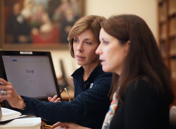 Researcher works with client at a computer