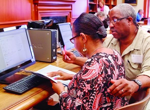 Couple does research at computer in a library