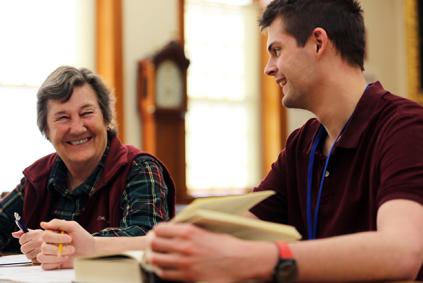 Two researchers smiling over a book