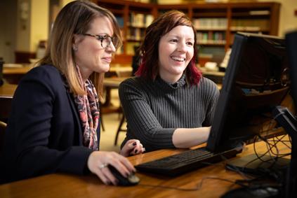 Two researchers look at a computer together